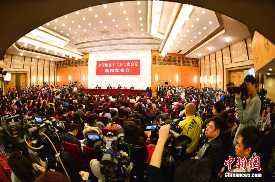 2014兩會首場發(fā)布會記者表情：“拍照神器”