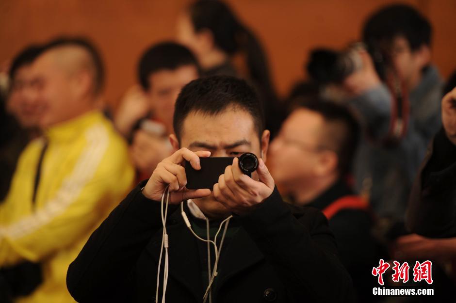 2014兩會首場發布會記者表情：“拍照神器”