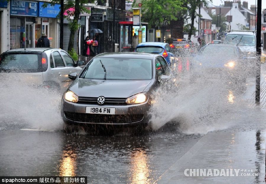 英國(guó)倫敦雨天狂風(fēng)大作 民眾出行雨傘被吹翻