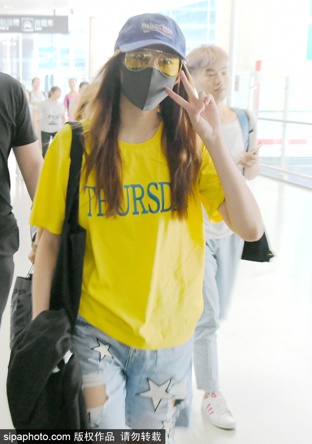 關曉彤黃T短褲踩拖鞋現身上海機場 獲眾人護駕見鏡頭比V賣萌