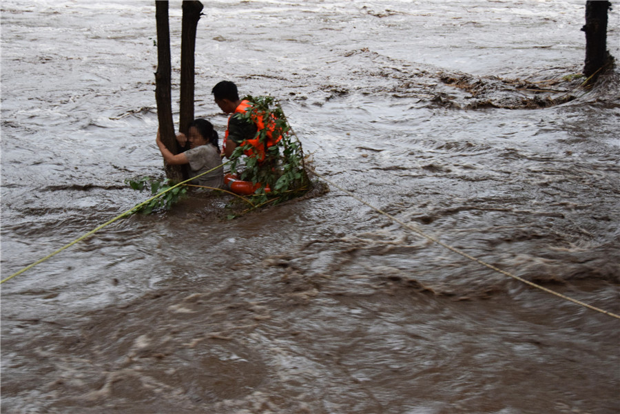 北京持續(xù)暴雨引發(fā)山洪 女子緊抱大樹被消防營救