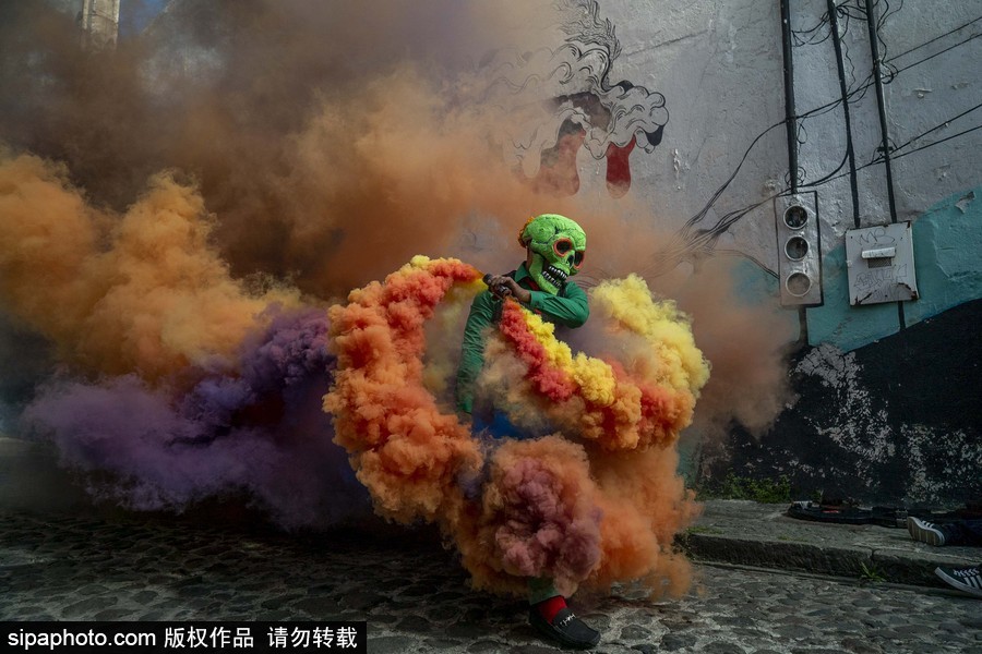 展現(xiàn)色彩魅力！墨西哥街頭“彩色骷髏”花6小時(shí)用彩煙“填滿”街道